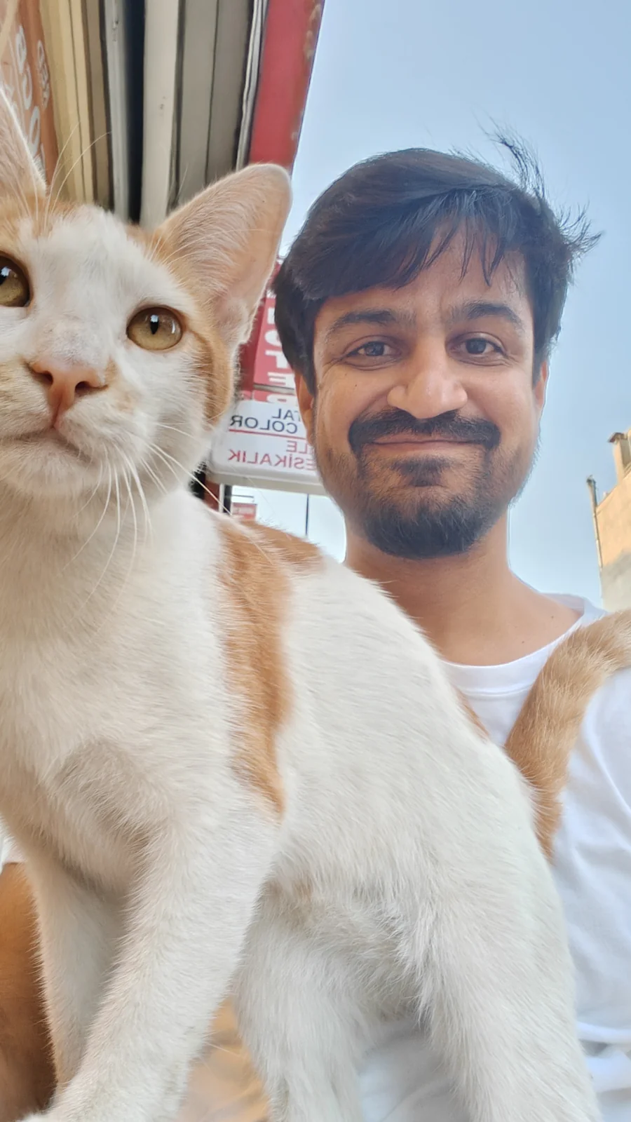 Jay taking a selfie with an orange-and-white cat on the cat’s adoption day